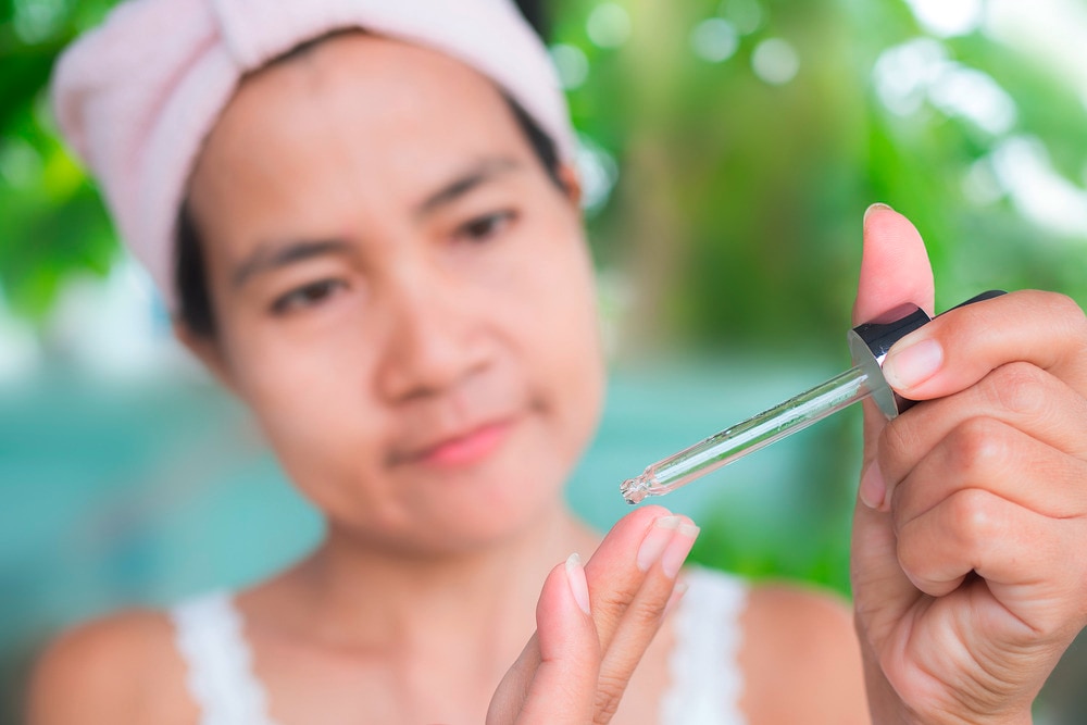 Woman takes a few drops of face serum