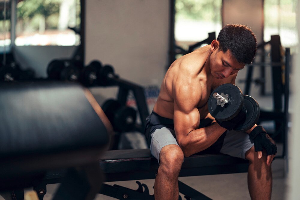 Asian bodybuilder working out at the gym.