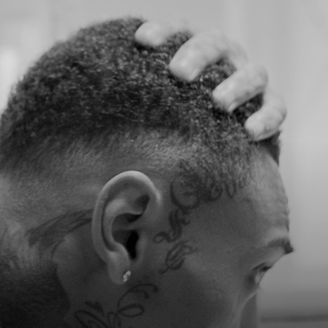 A guy with freckles, spraying fragrance.