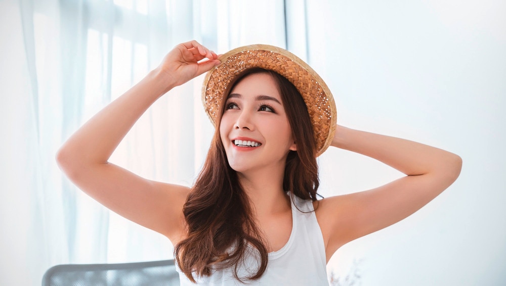 A portrait of smiling woman wearing straw hat.