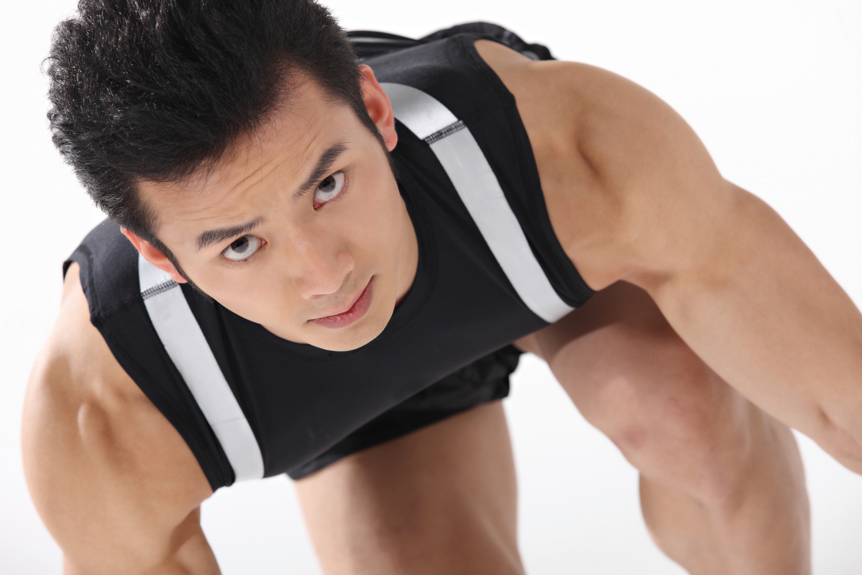 Asian man in black tank top looking at the camera.