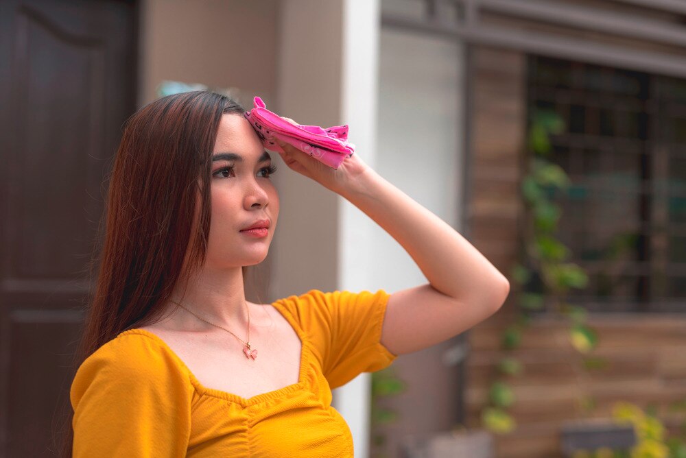 Long-haired Asian woman wiping her sweat.