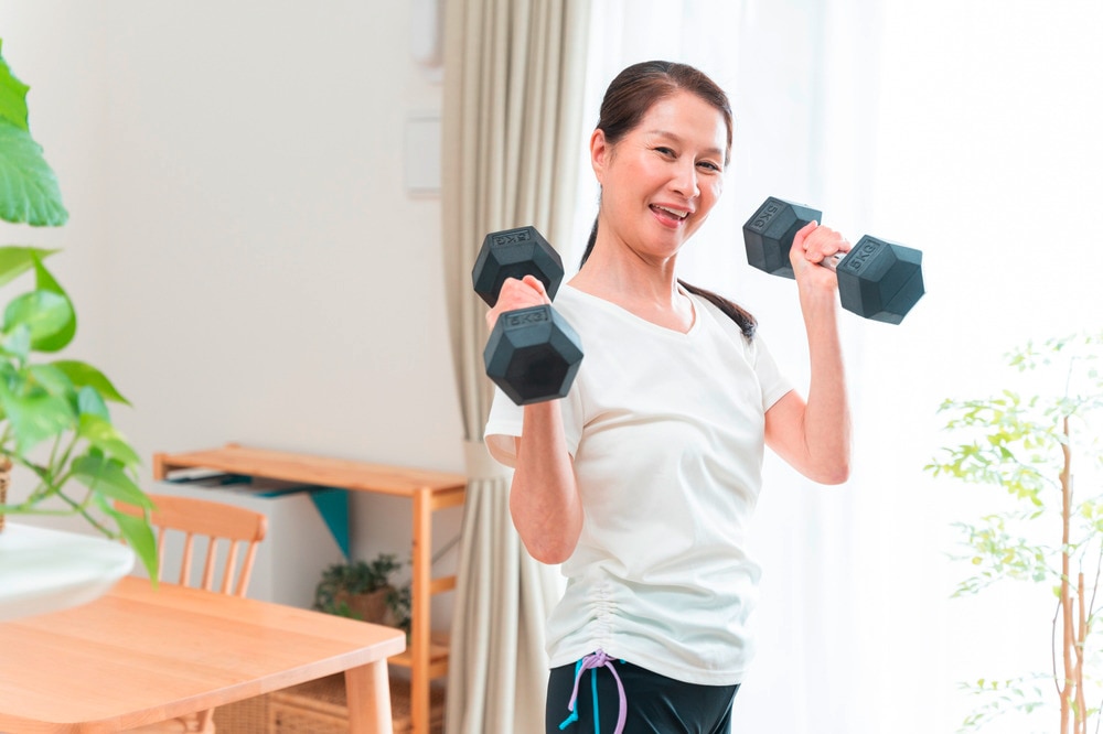 Senior Asian woman doing strength training at home.