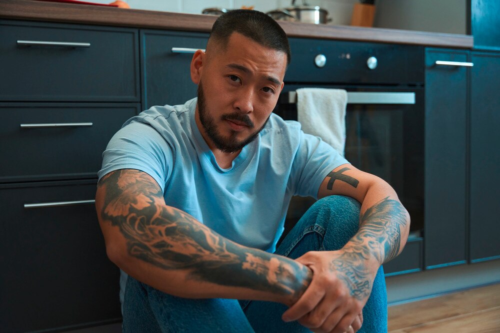 Man with a defeated look sits on the floor