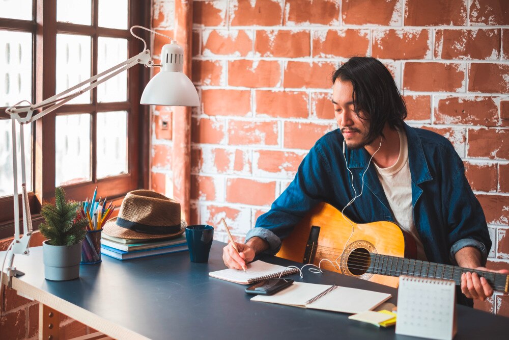 Man writing a song with an acoustic guitar