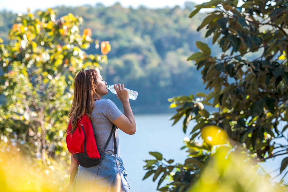 Female hiker drinking water from a bottle.