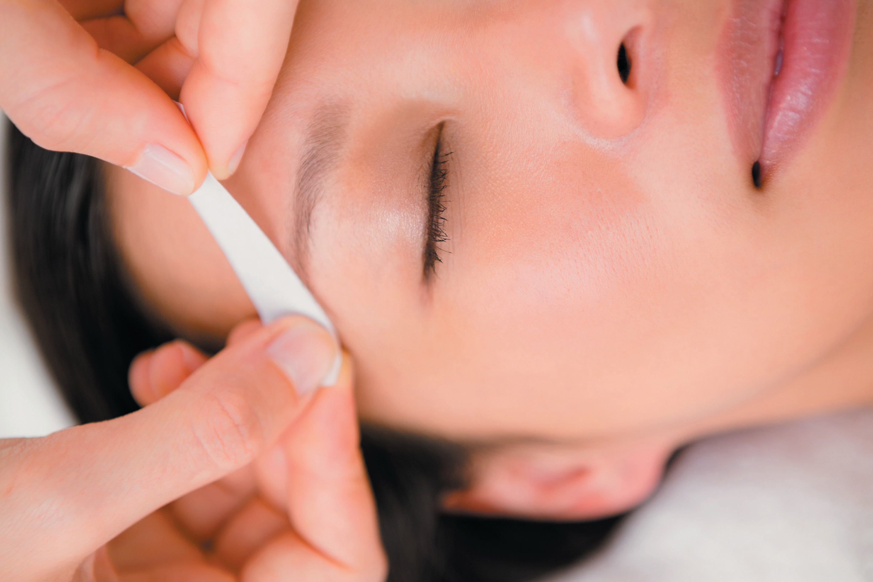 Close up of a woman getting eyebrows waxed