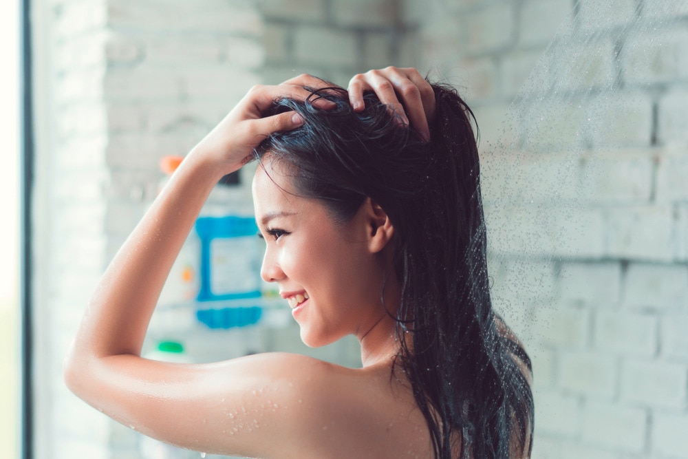 Woman washing her long hair in the shower.