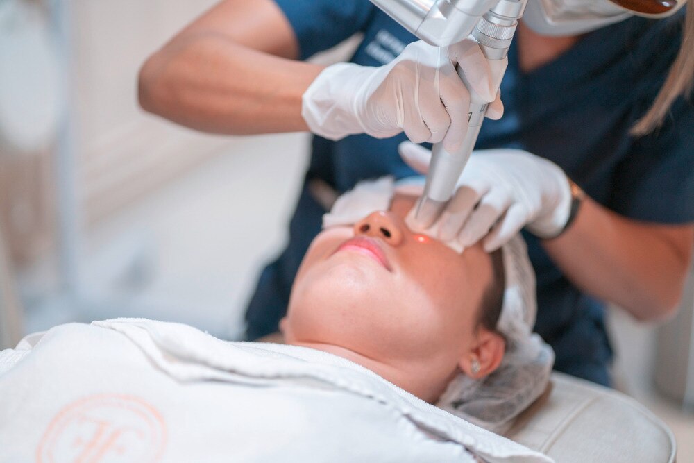 A portrait of technician doing laser therapy on a patient’s face.