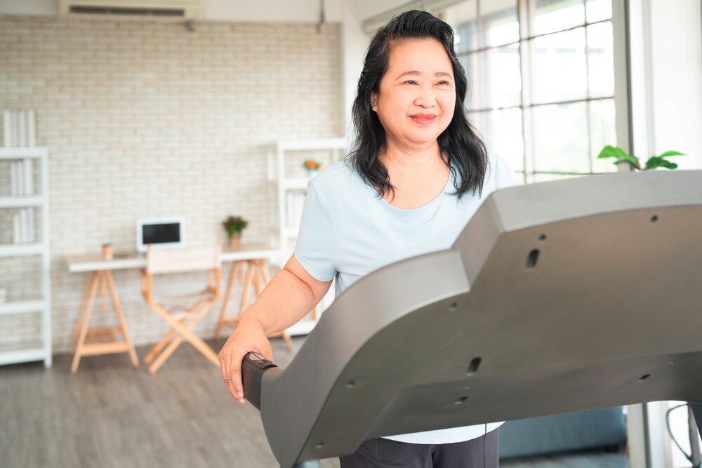 Senior Asian woman on the treadmill at home.