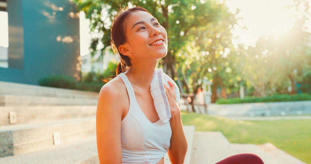 Asian woman in sportswear sweating after exercise.