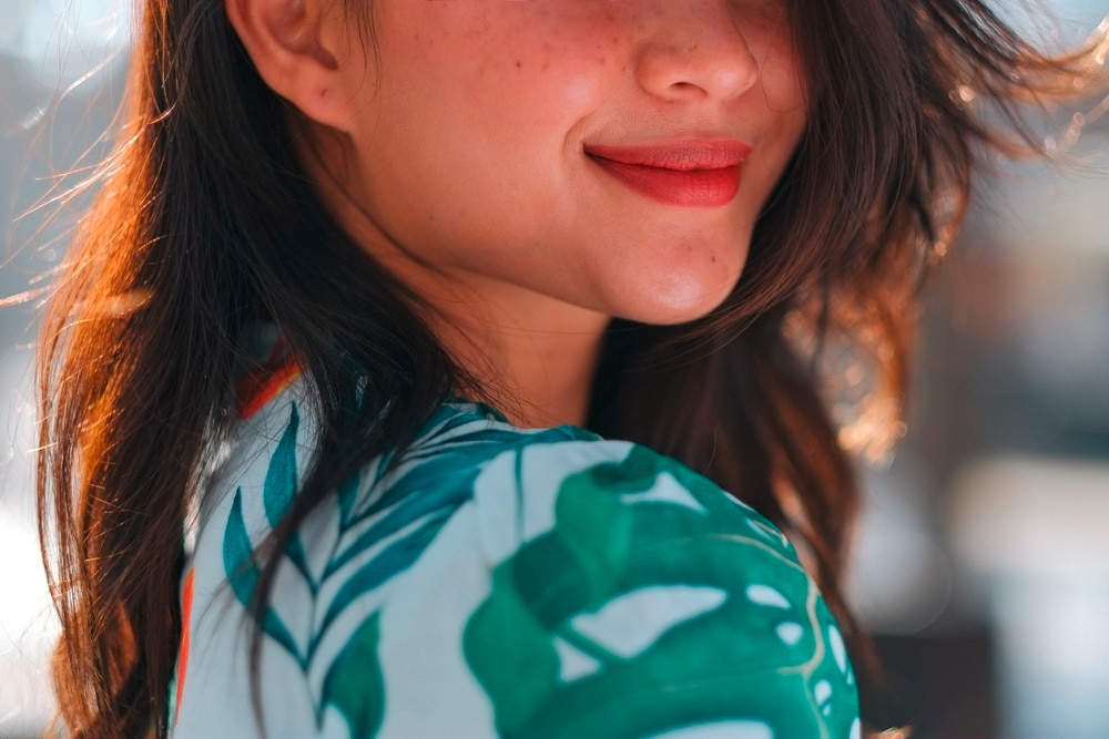 A portrait of smiling woman with freckles on her face.