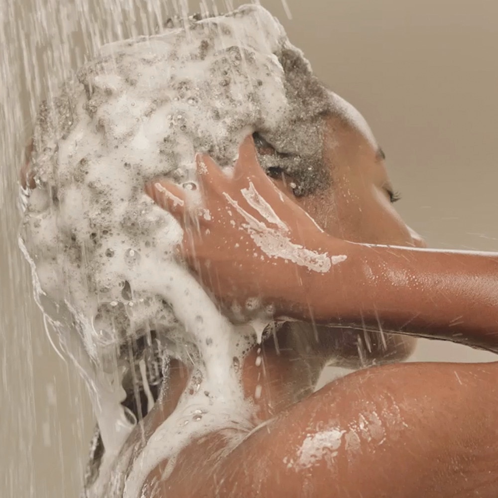 A beautiful woman washing her hair with teh perfect shampoo for her hair. 
