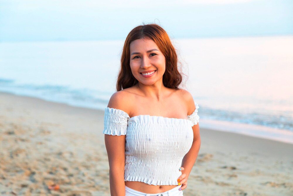 A portrait of smiling woman at the beach.