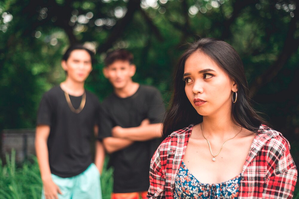 A portrait of woman getting catcalled by men.