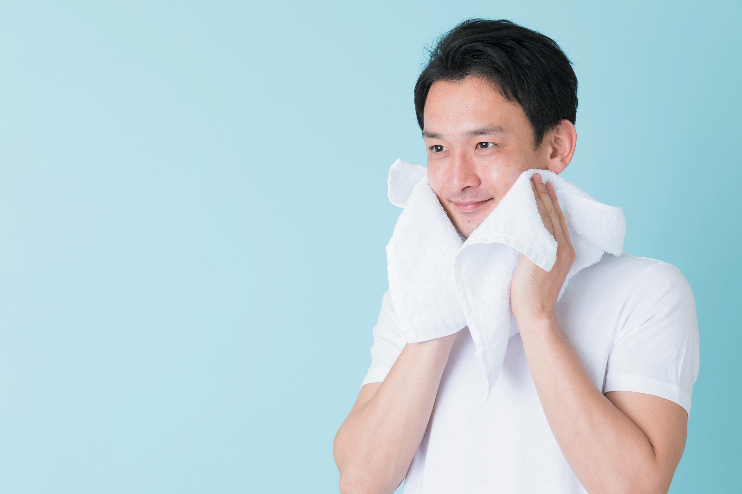 Asian man drying his face with towel