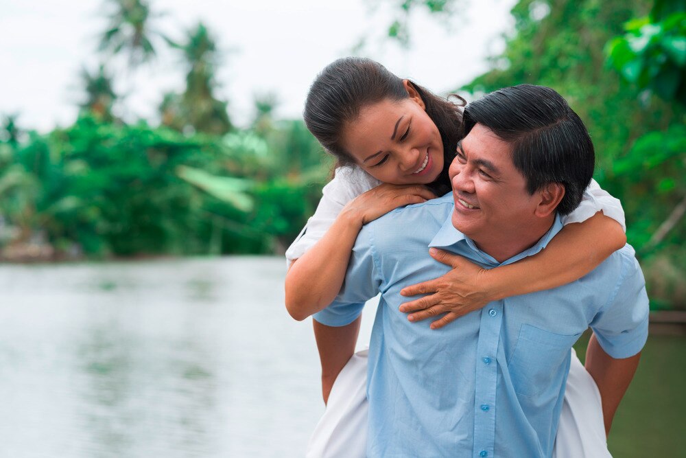 Asian woman and Asian man having fun outdoors.