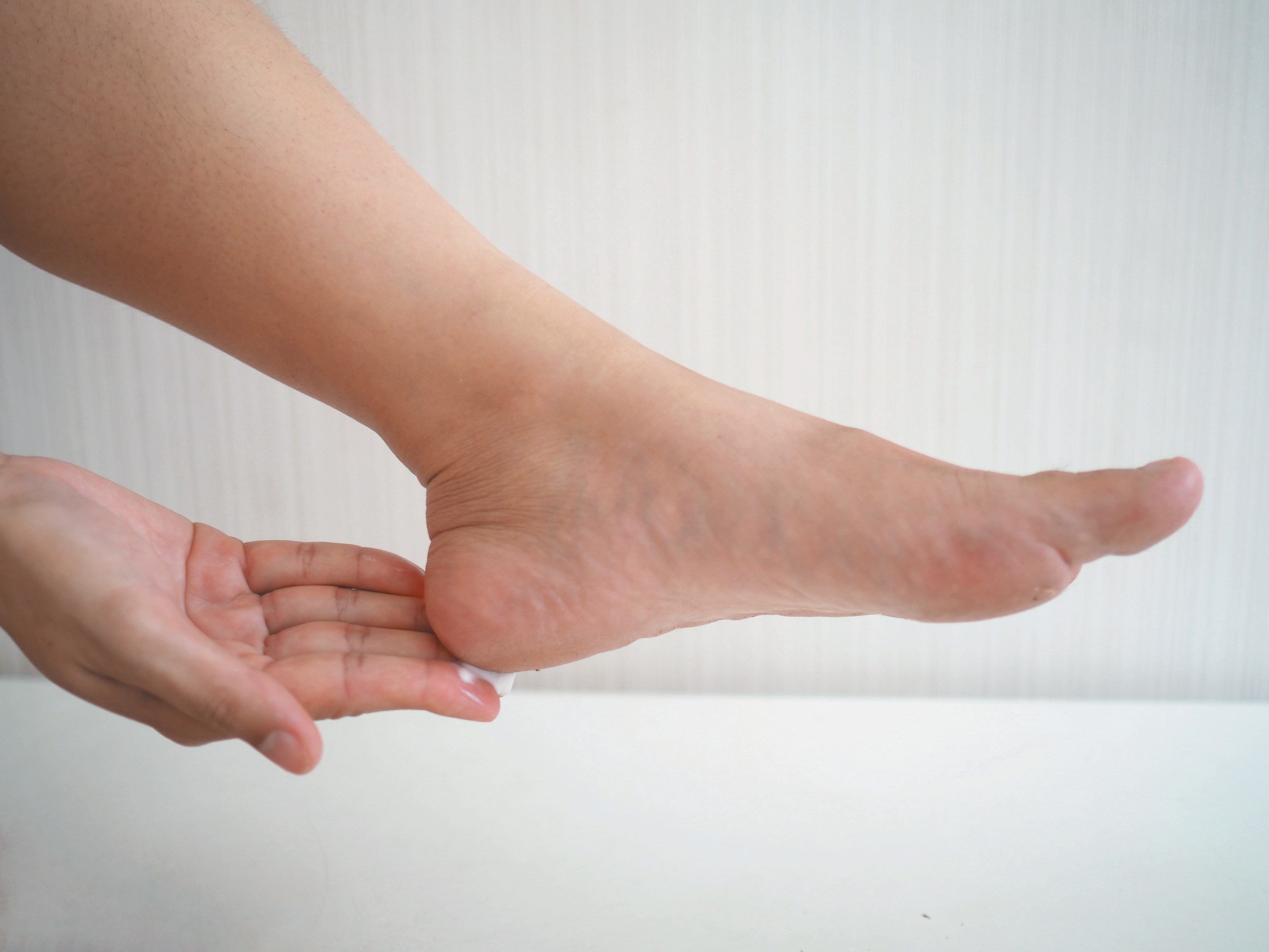Woman applying cream on heel