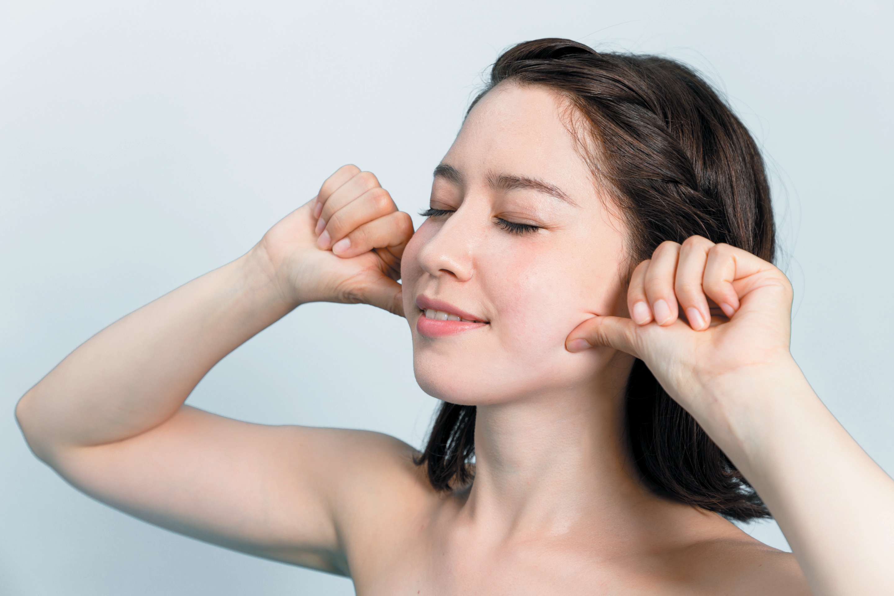 Asian woman massaging her face