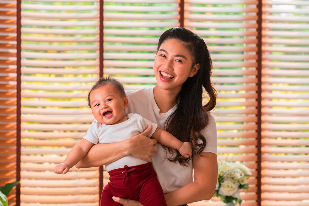 Happy Asian mom with smiling baby.