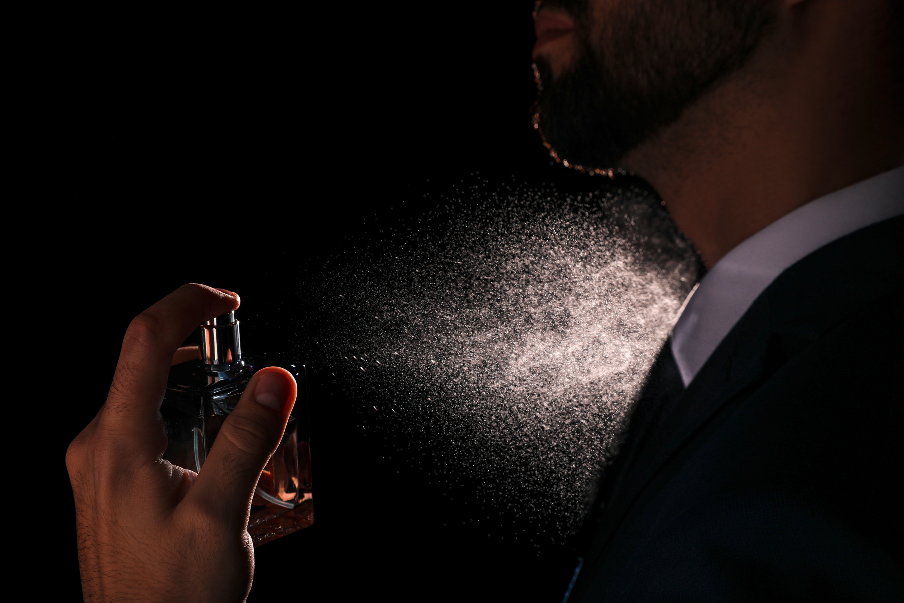 pria sedang menyemprotkan body mist