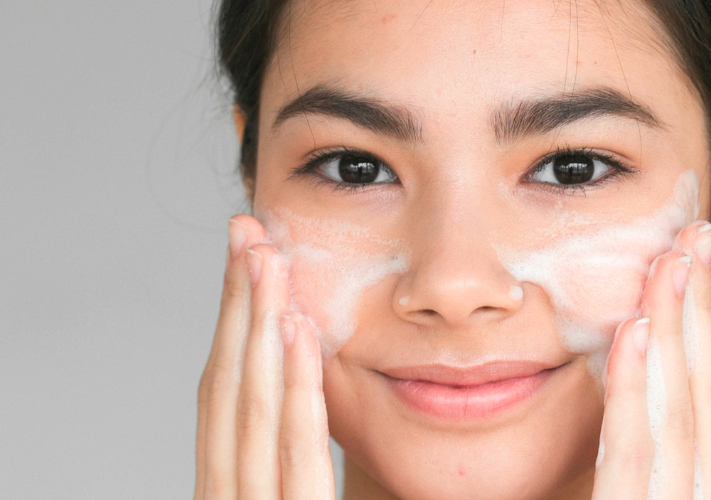 Young Asian girl with cleansing with facial foam 
