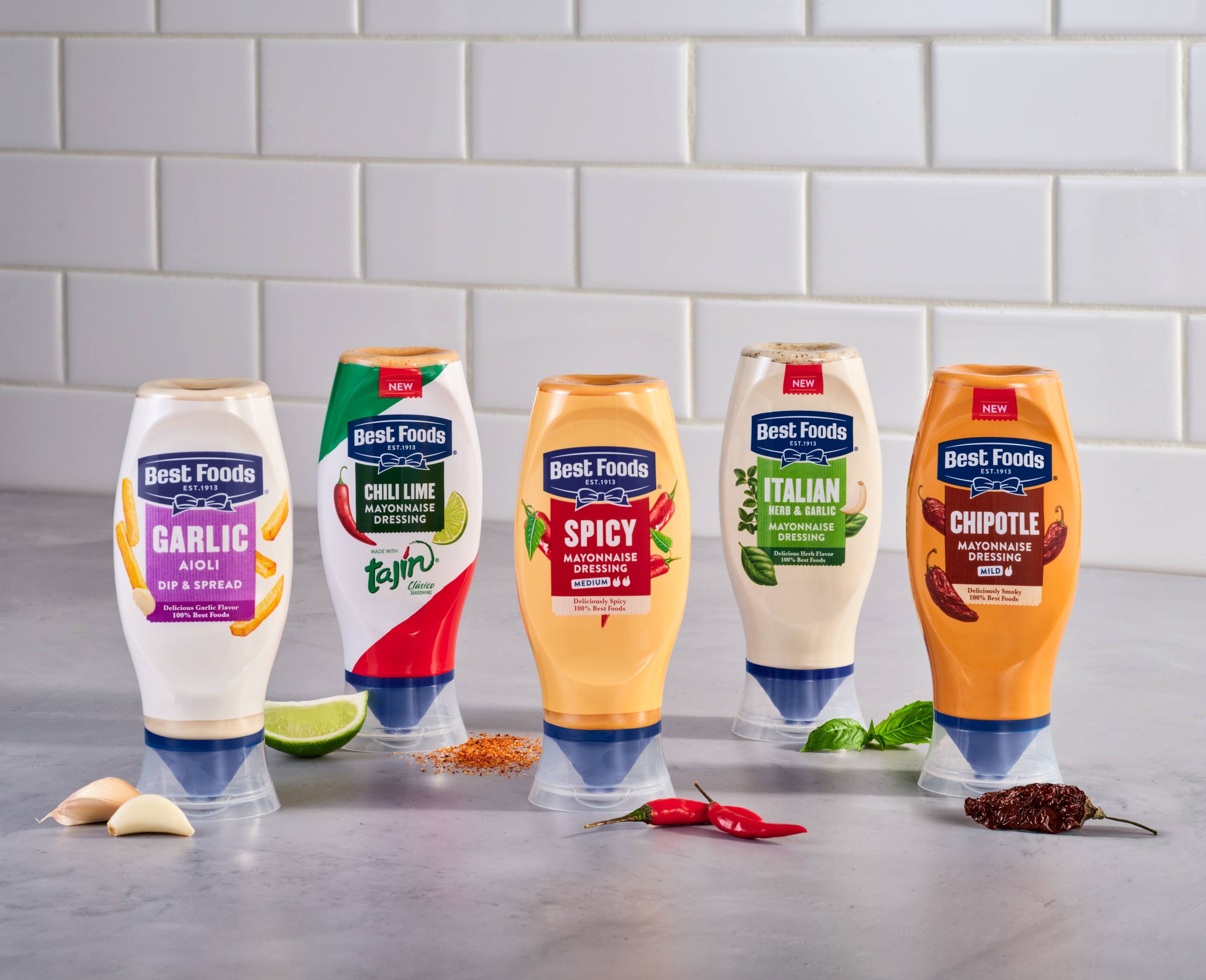 A line-up of Best Foods flavoured, squeeze bottle mayos pictured with key ingredients like limes, chillies, garlic and herbs.