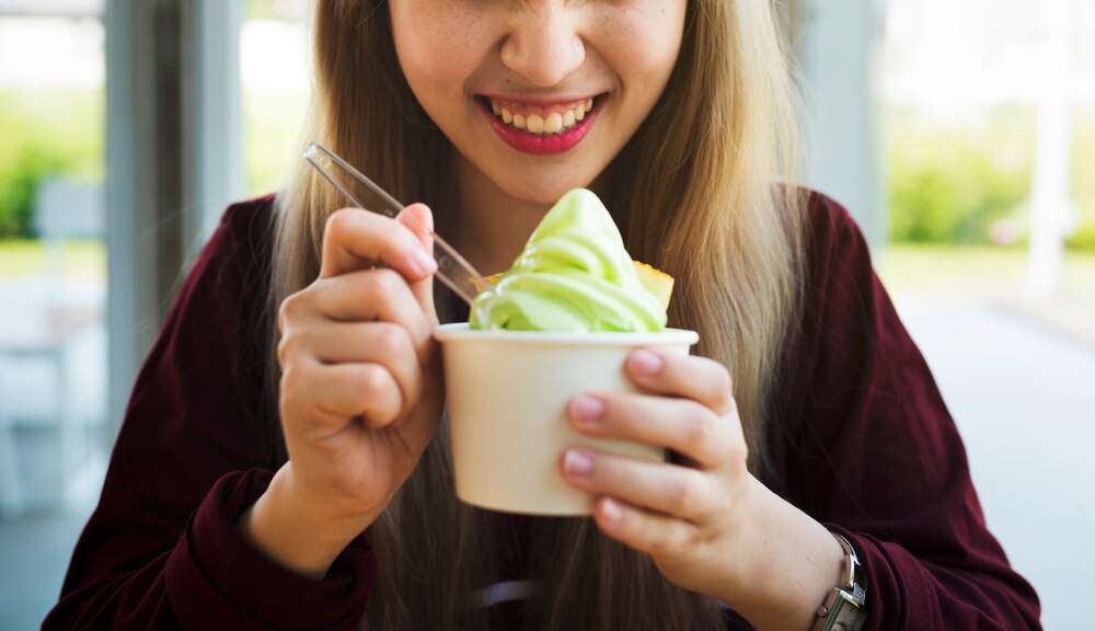 Woman holding a cup of soft serve ice cream.
