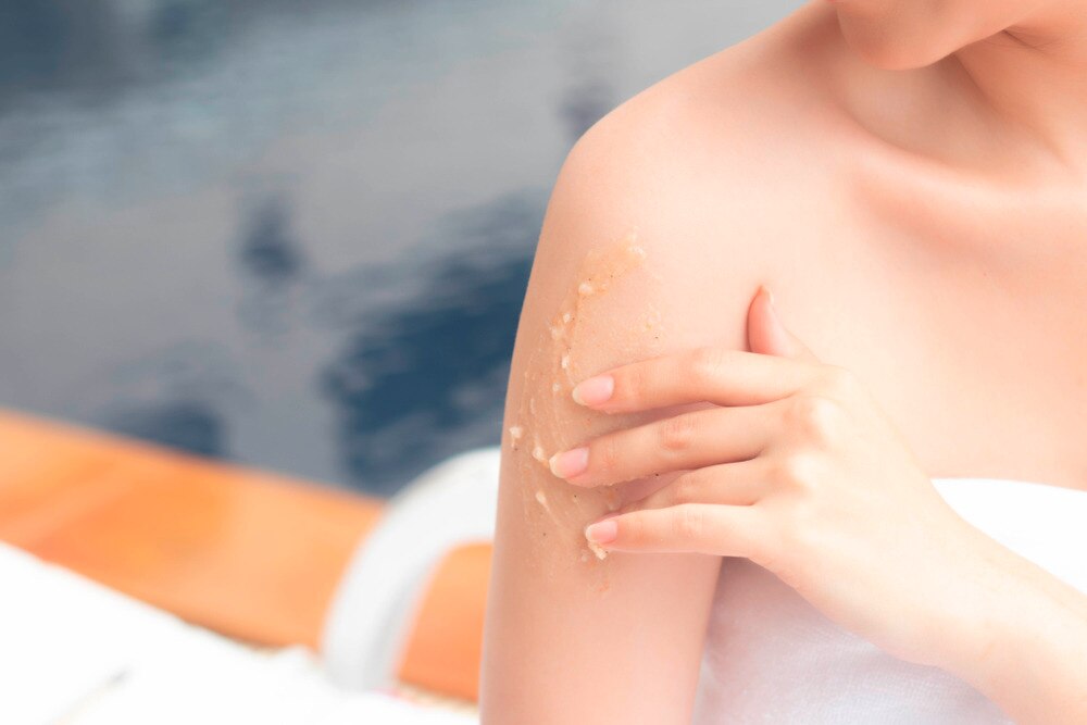 Asian woman scrubbing her arm