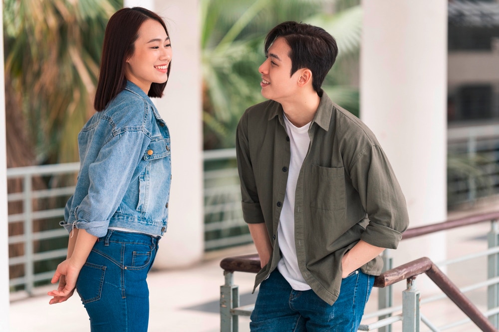 A portrait of Asian man flirting with a woman.