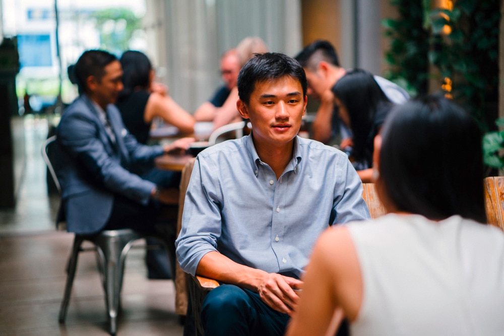  Asian man and woman on a date at a café.