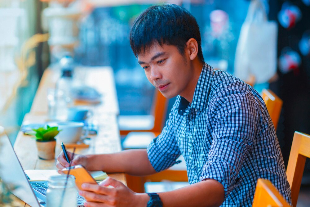 Asian man working at a coffee shop.