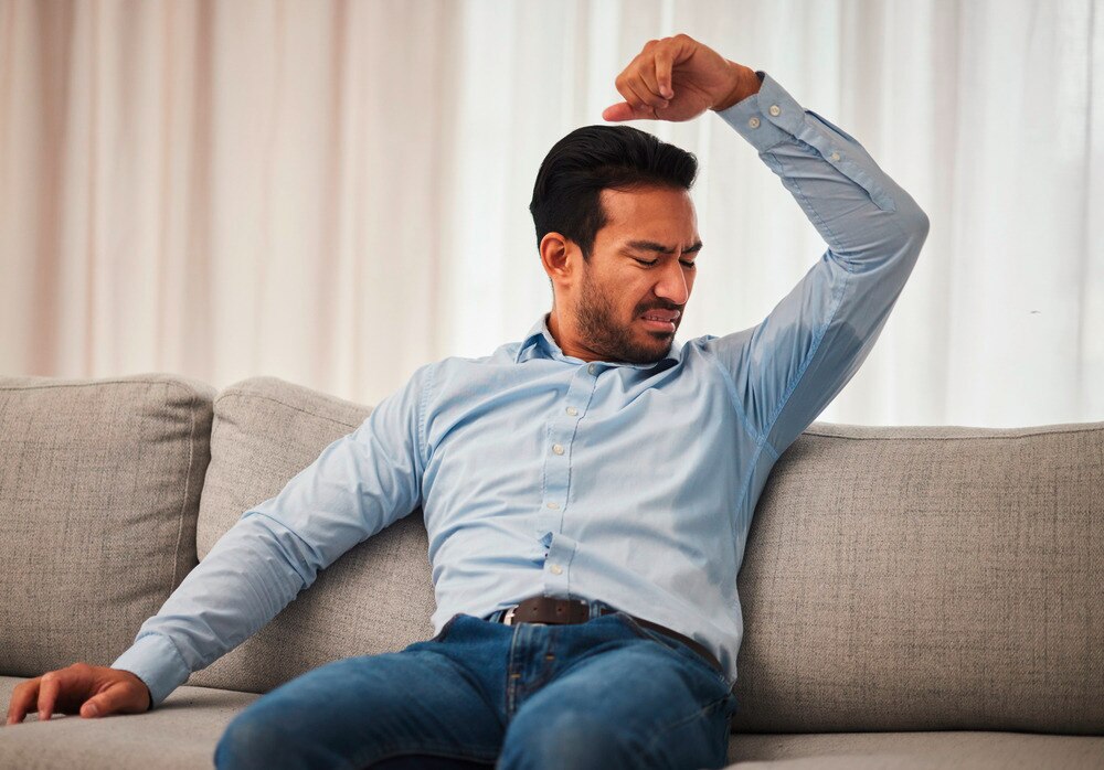 Man with sweaty armpit in a long-sleeved shirt.