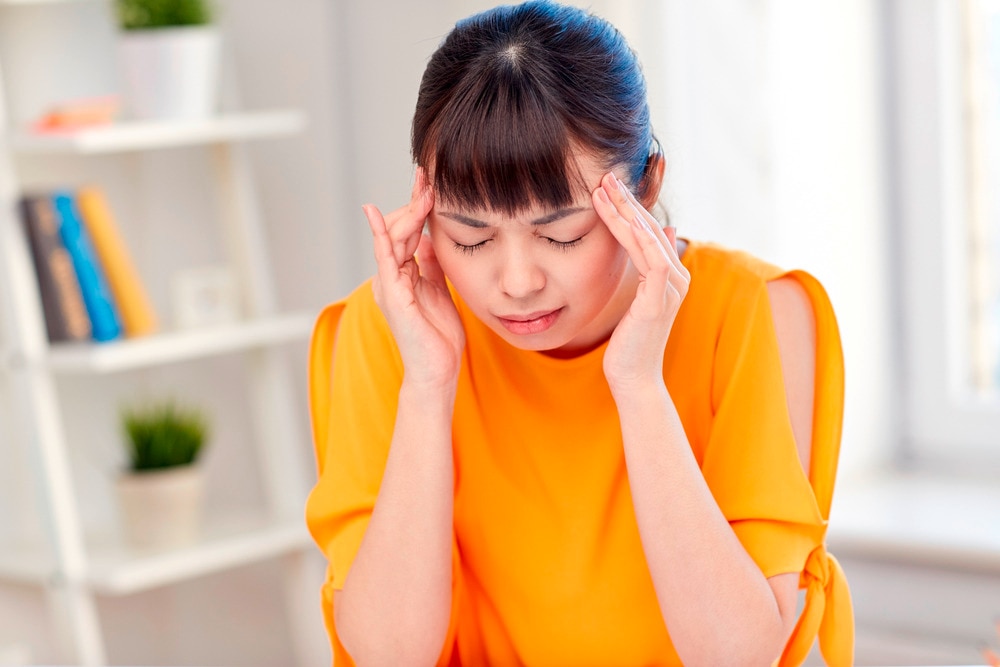 A portrait of woman suffering from headache.