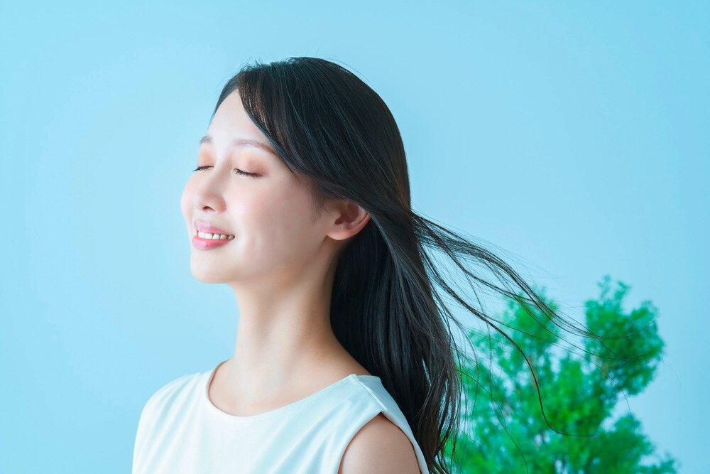 A portrait of woman with her hair blowing in the wind.