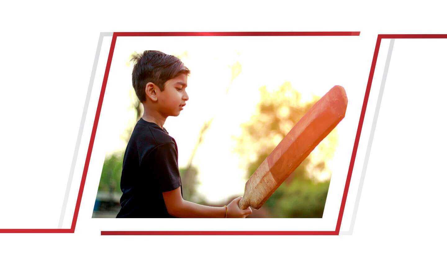 little boy batting in field