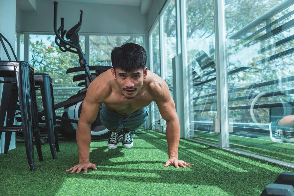 A portrait of man doing push-ups at the gym.