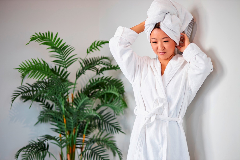 Woman wearing towel wrapped over her hair and bathrobe.