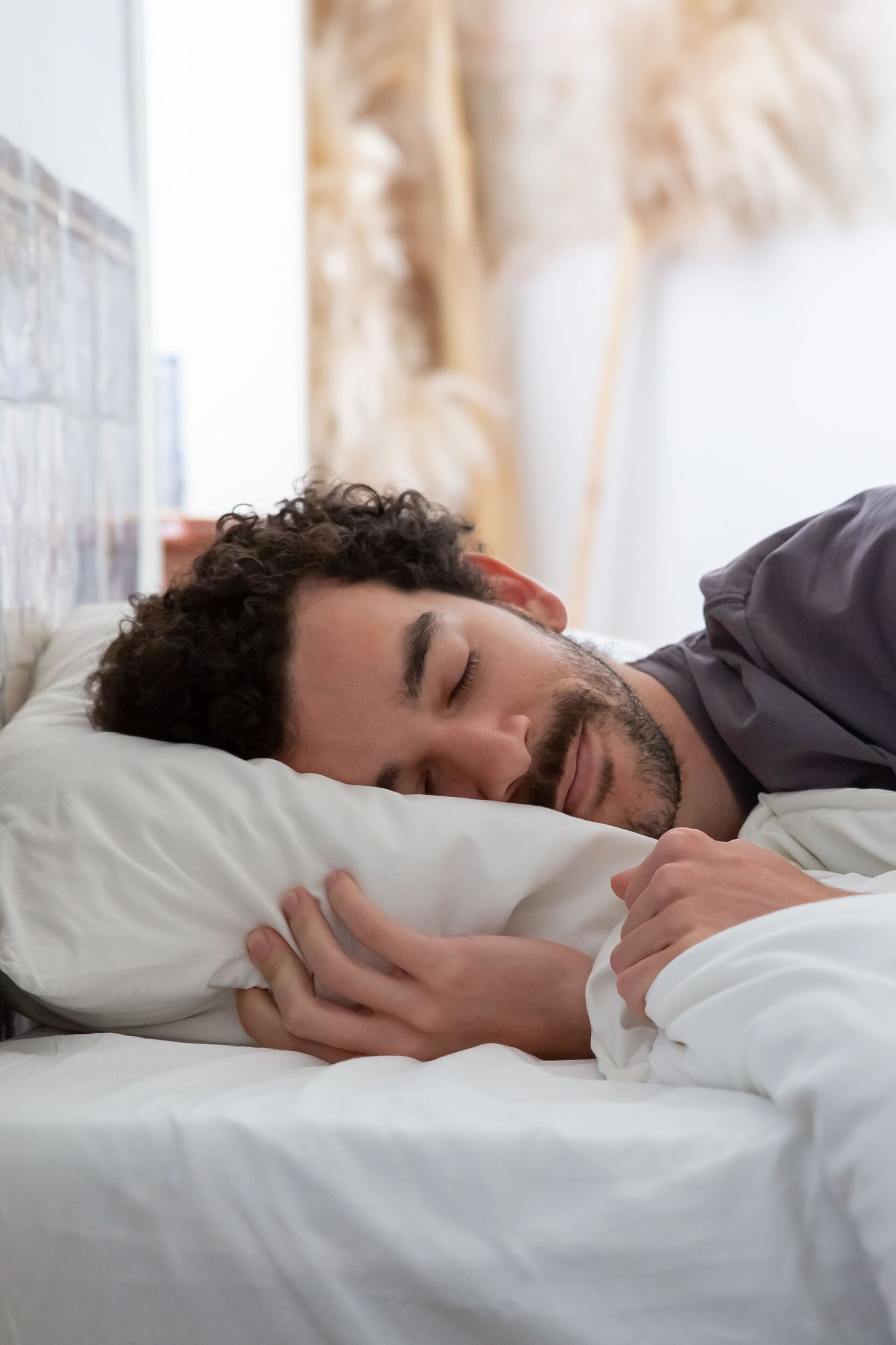 Man sleeping in comfortable bed with white linen