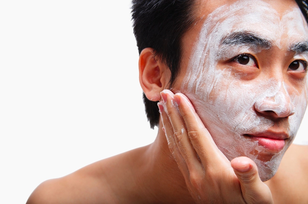 Closeup of Asian man with soap on face.