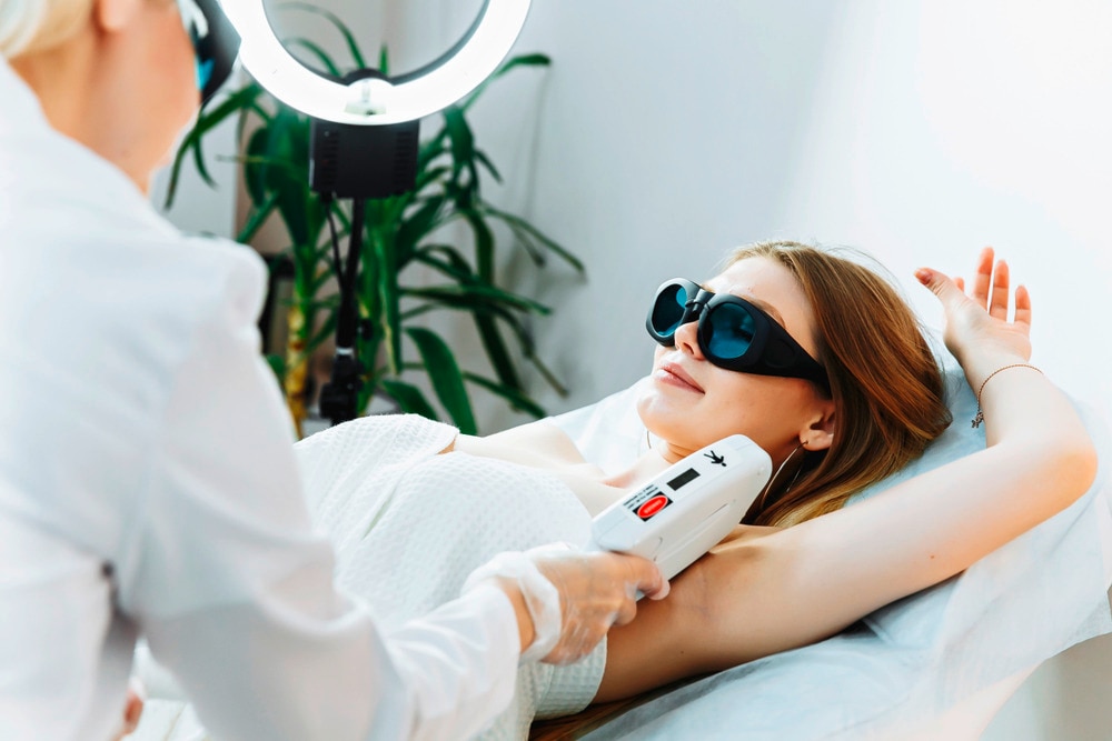 A portrait of woman getting a laser treatment for her underarms.