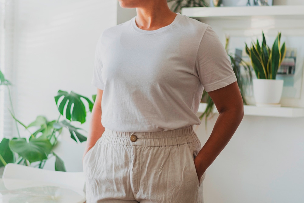 A portrait of woman wearing white T-shirt and linen shorts.