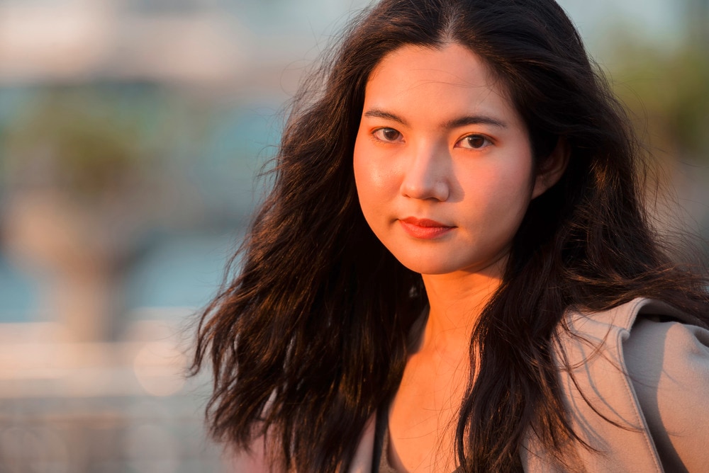 Woman with long, wavy hair blowing in the wind.
