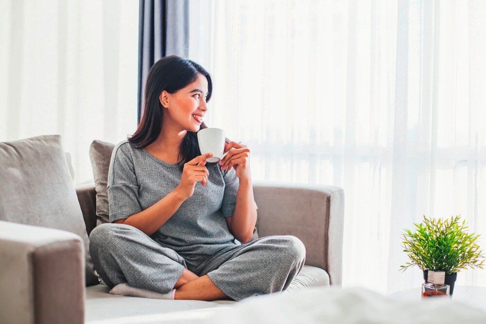 Asian woman in gray sitting on couch