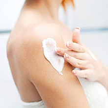 A person is shown applying cream onto their lip.