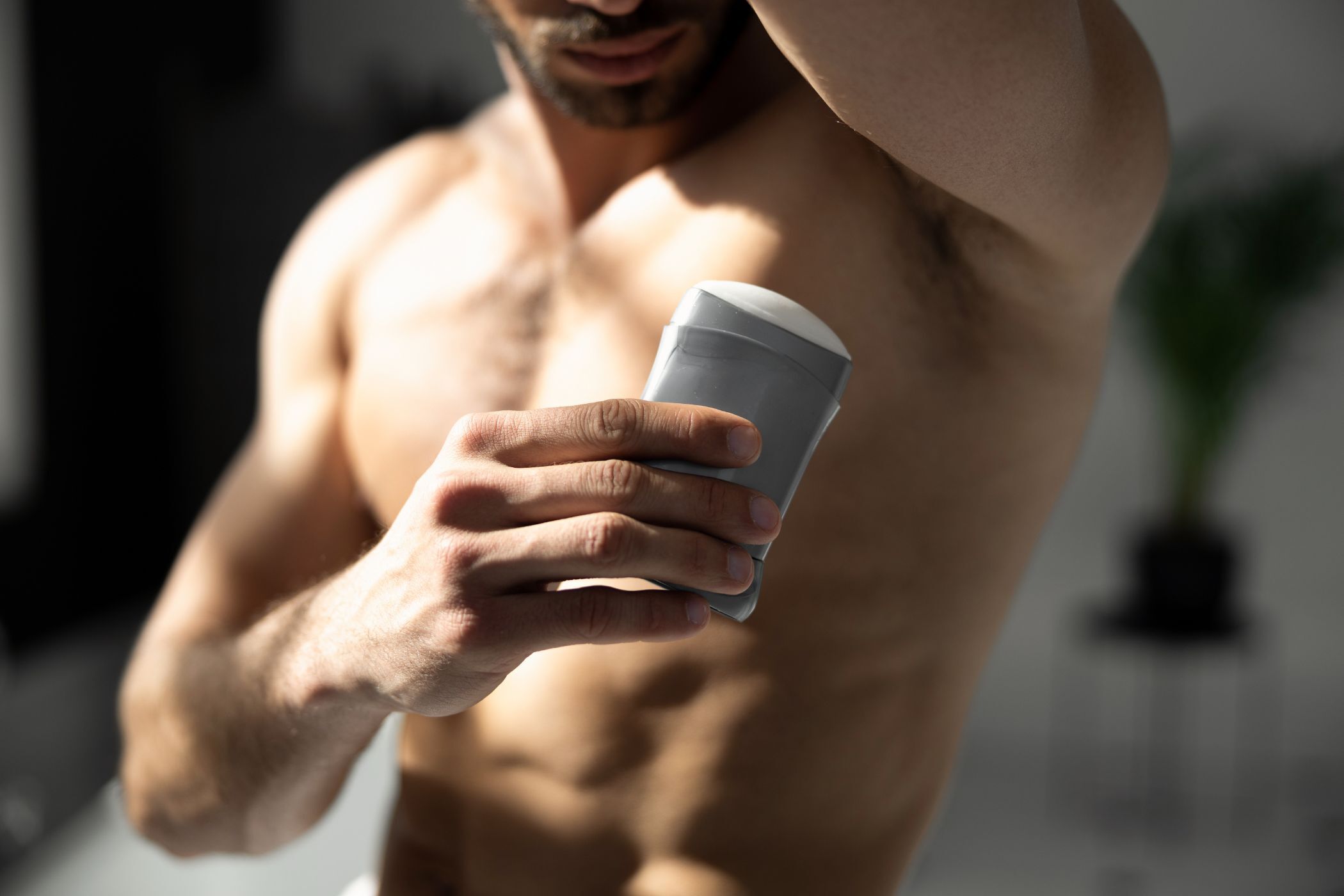 Cropped shot of young man applying deodorant