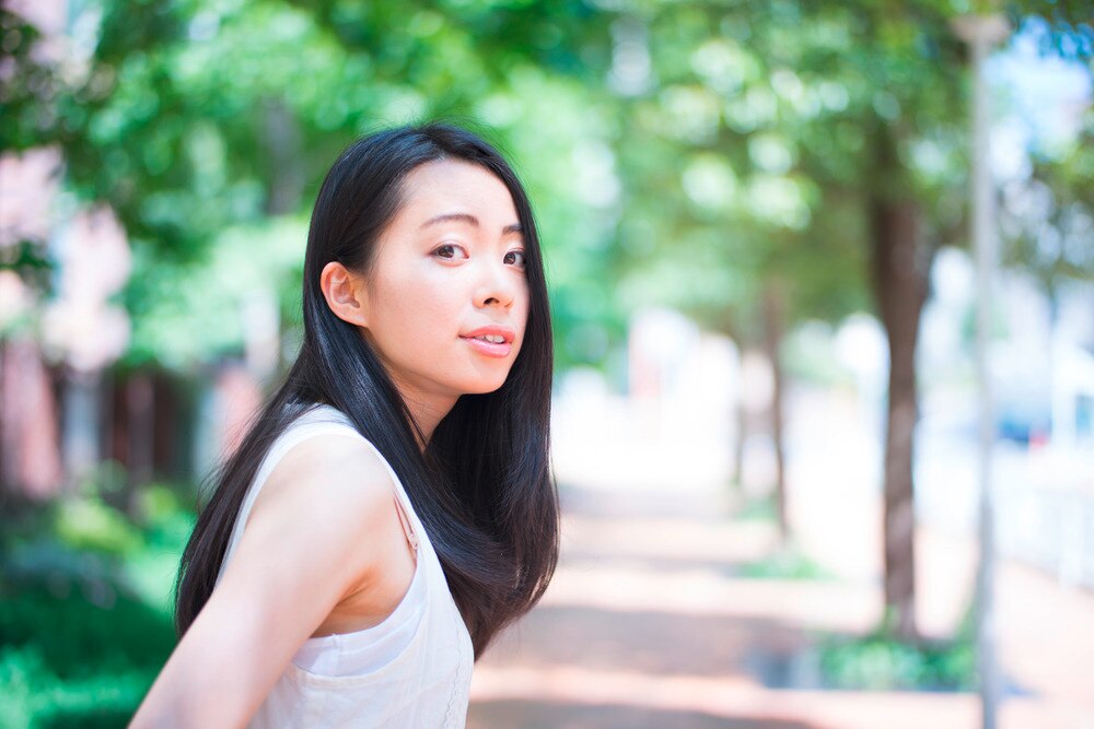 Asian woman with long hair at a park.