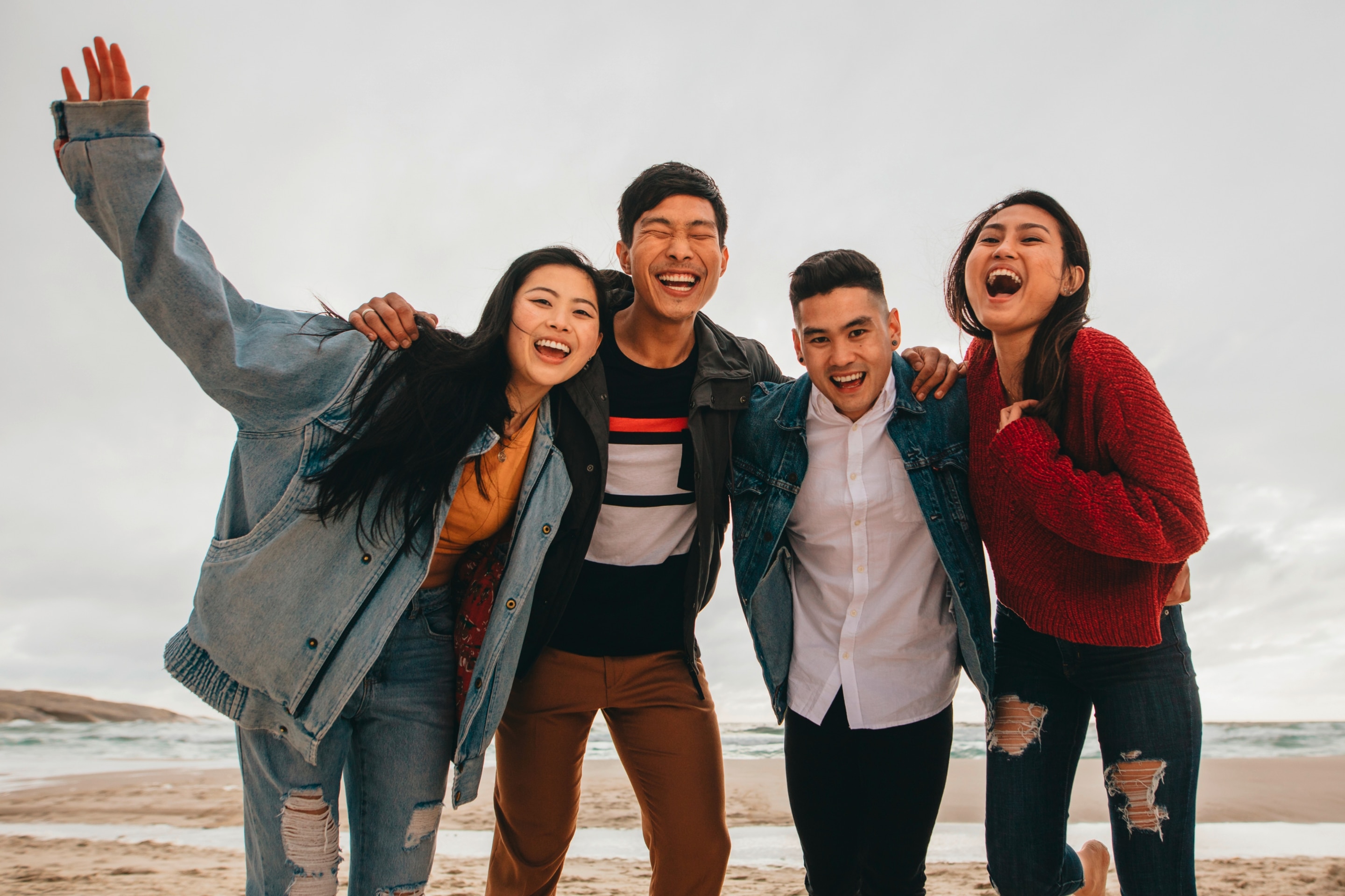 Sekelompok pria dan wanita asia sedang bersenang-senang di pantai