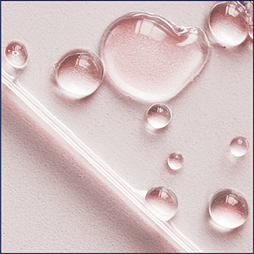 A person is shown looking forwards. They are wearing sunglasses and smiling as the sun is shining on them.