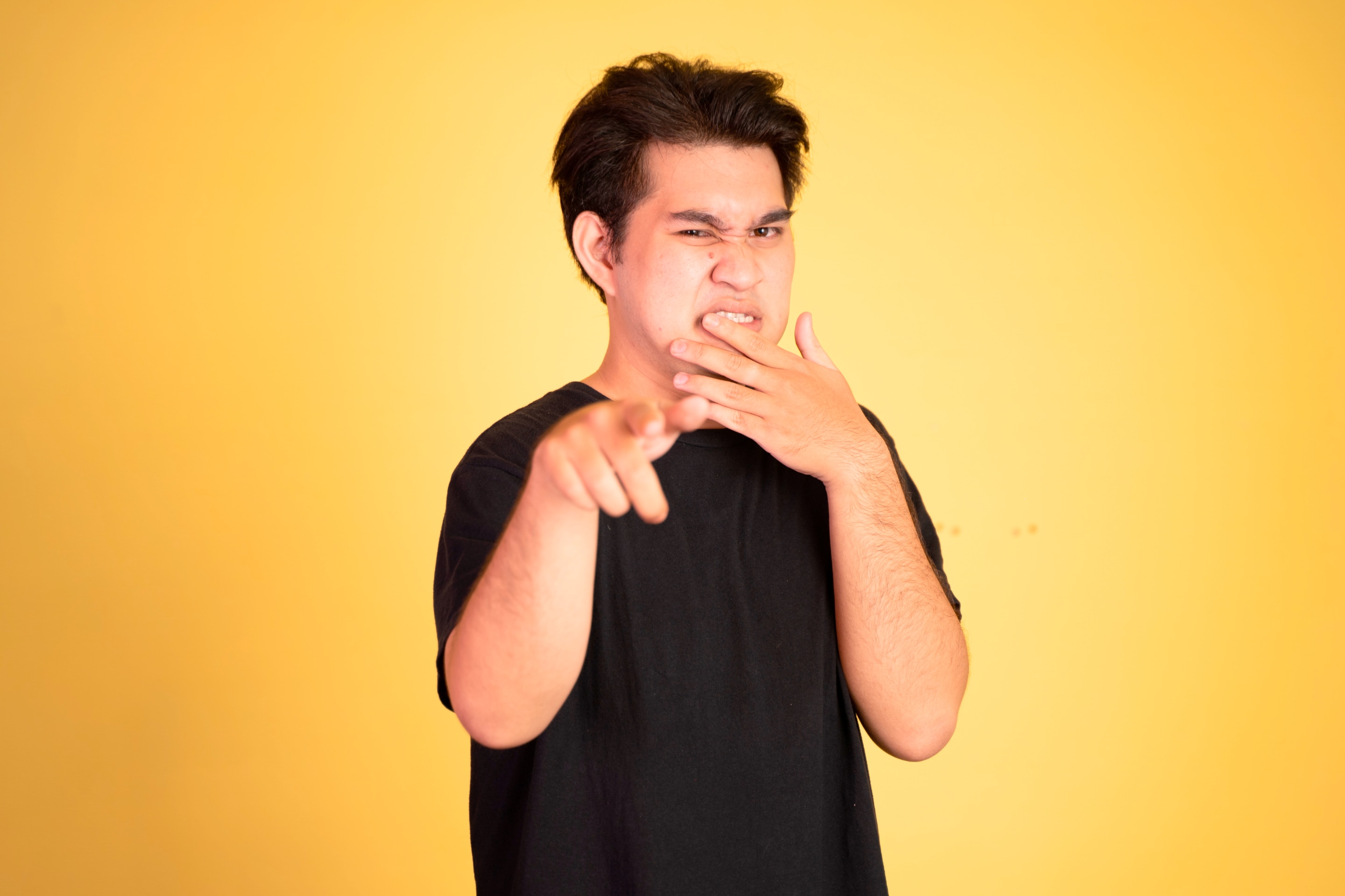 pria asia yang sedang menunjukkan gesture membully